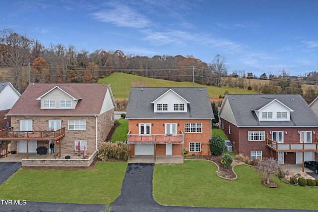 view of front of property with a garage, a wooden deck, and a front yard