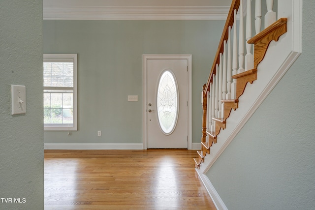 entrance foyer with crown molding and light hardwood / wood-style floors