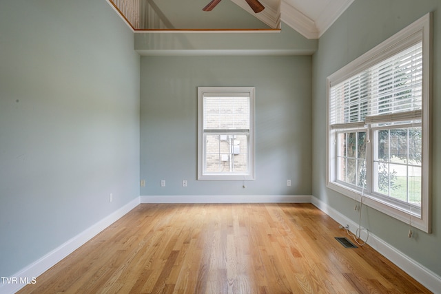 empty room with plenty of natural light, light hardwood / wood-style floors, and ornamental molding