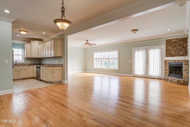 unfurnished living room with ceiling fan, crown molding, a healthy amount of sunlight, and light wood-type flooring