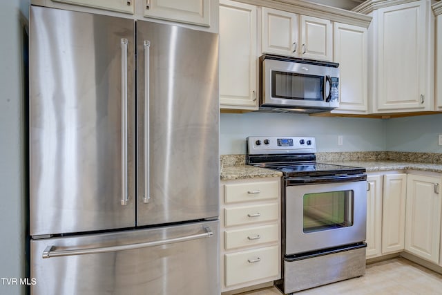 kitchen with light stone countertops and appliances with stainless steel finishes