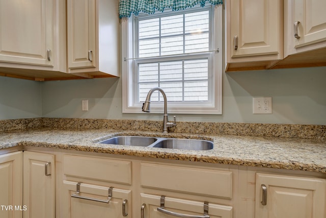 kitchen featuring light stone countertops and sink