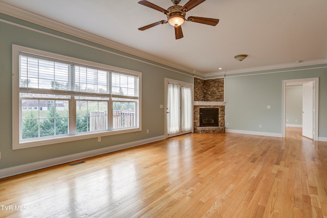 unfurnished living room featuring a fireplace, crown molding, light hardwood / wood-style flooring, and a healthy amount of sunlight