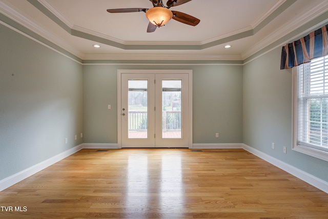 spare room with a wealth of natural light, crown molding, and light hardwood / wood-style floors