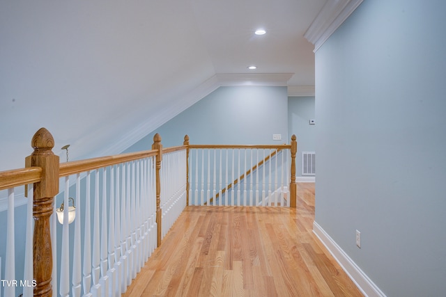 hall with hardwood / wood-style floors, crown molding, and vaulted ceiling