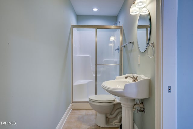 bathroom featuring toilet, tile patterned floors, and a shower with door