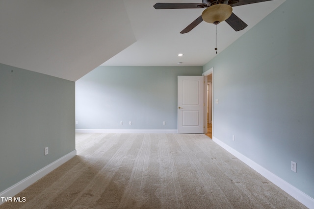 unfurnished room with ceiling fan, light colored carpet, and vaulted ceiling