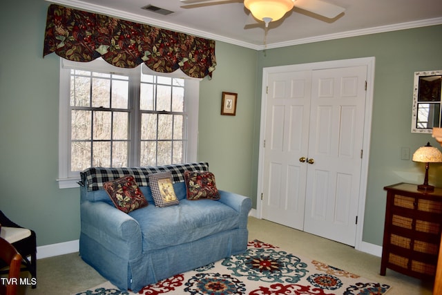 living area with light carpet, ceiling fan, and ornamental molding