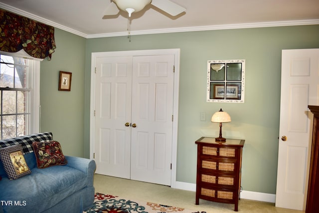 living area featuring ceiling fan, crown molding, and light carpet