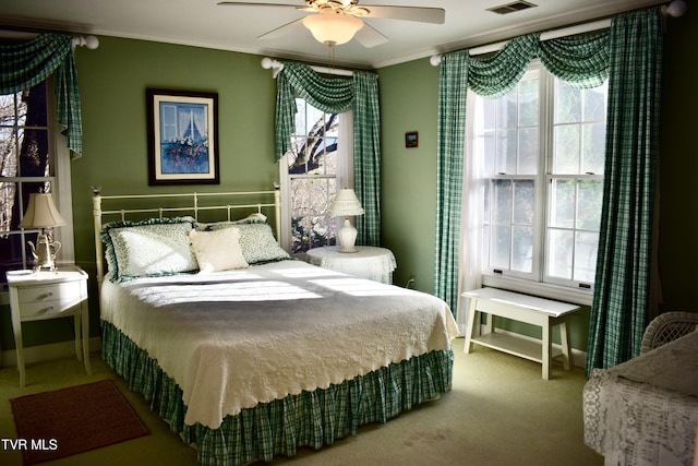 carpeted bedroom with multiple windows, crown molding, and ceiling fan