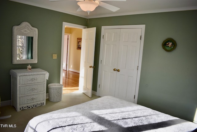 carpeted bedroom featuring a closet, ceiling fan, and ornamental molding