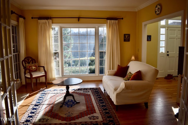 sitting room with dark hardwood / wood-style flooring and crown molding