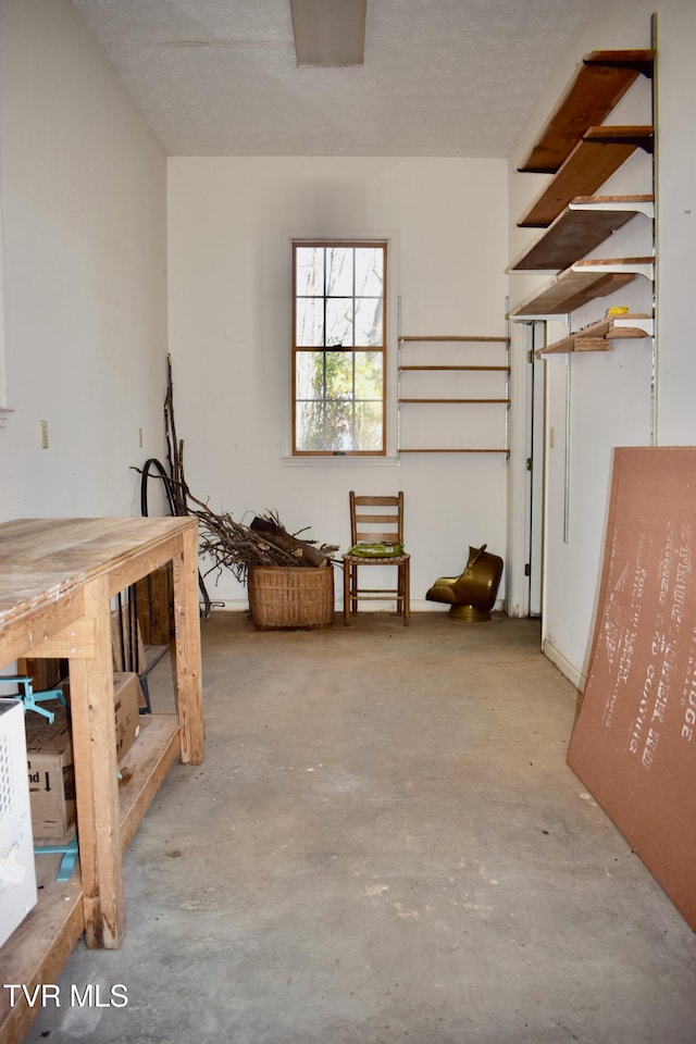 interior space with a textured ceiling and concrete floors