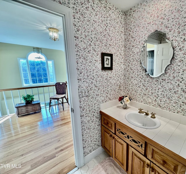 bathroom with hardwood / wood-style floors, vanity, and a chandelier