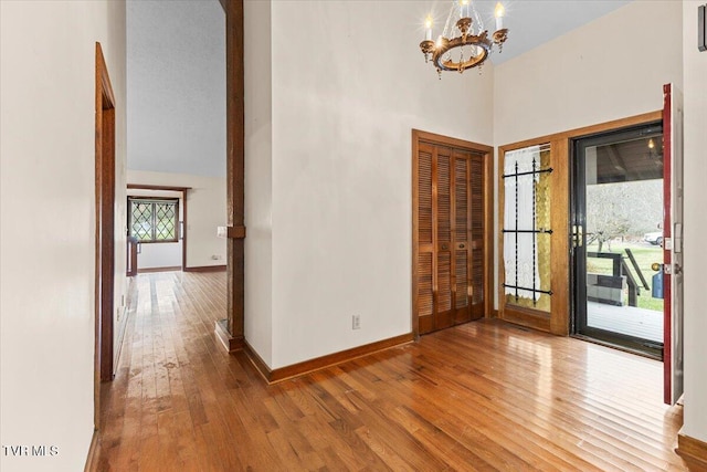 entryway with plenty of natural light, a towering ceiling, and hardwood / wood-style floors