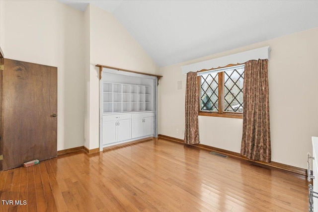 unfurnished bedroom with hardwood / wood-style floors and high vaulted ceiling