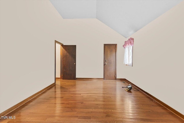 spare room with vaulted ceiling and light wood-type flooring