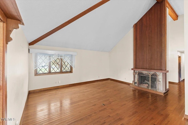 unfurnished living room featuring vaulted ceiling with beams and wood-type flooring