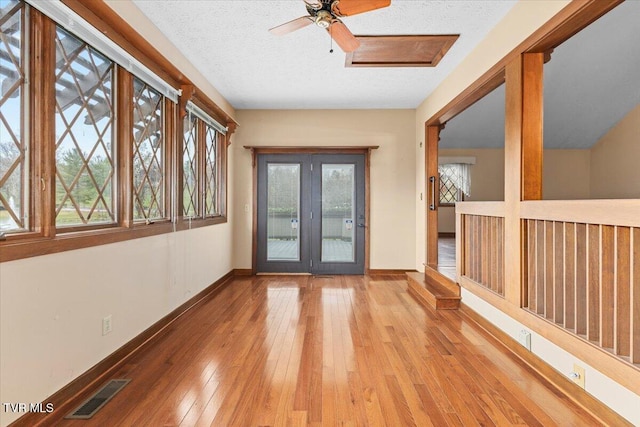 interior space featuring hardwood / wood-style floors, a textured ceiling, and a healthy amount of sunlight