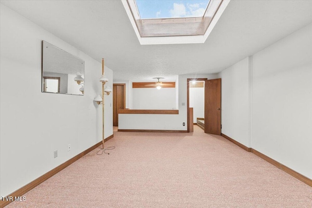 carpeted spare room featuring a skylight