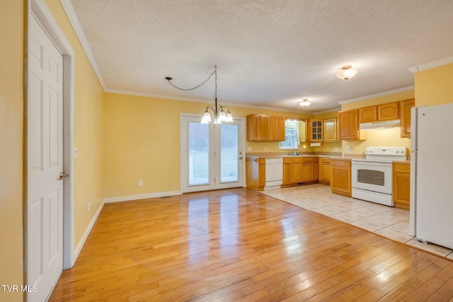 kitchen with an inviting chandelier, pendant lighting, a textured ceiling, white appliances, and light wood-type flooring