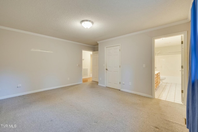 empty room featuring ornamental molding, a textured ceiling, and light carpet