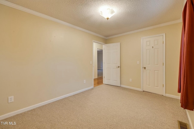 unfurnished bedroom with light colored carpet, a textured ceiling, and ornamental molding