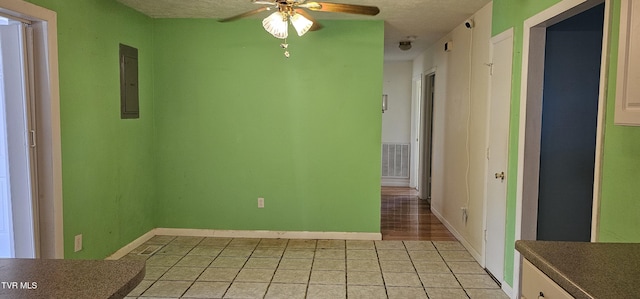 20286 Shadowood Cir, Meadowview, VA 24361 - unfurnished dining area featuring electric panel, ceiling fan, light tile patterned flooring, and a textured ceiling