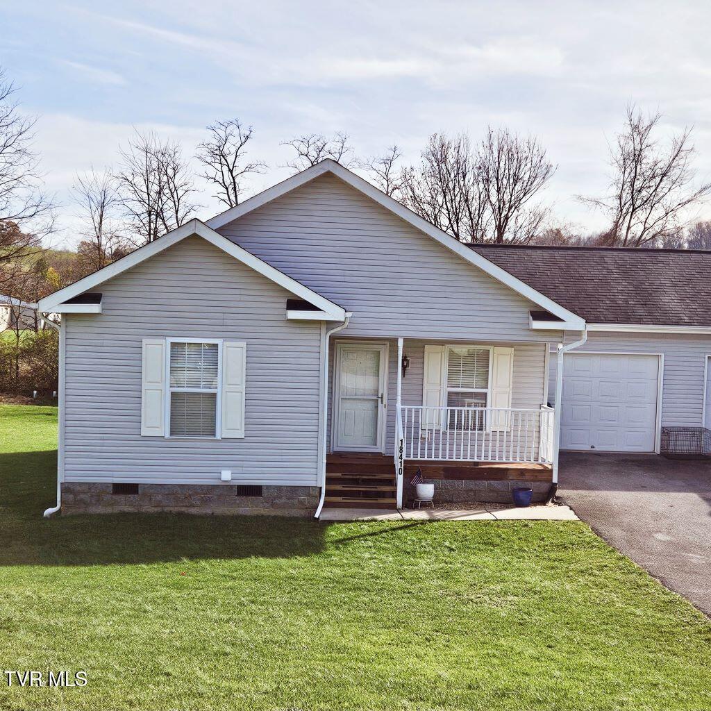 ranch-style home with a front lawn, a porch, and a garage