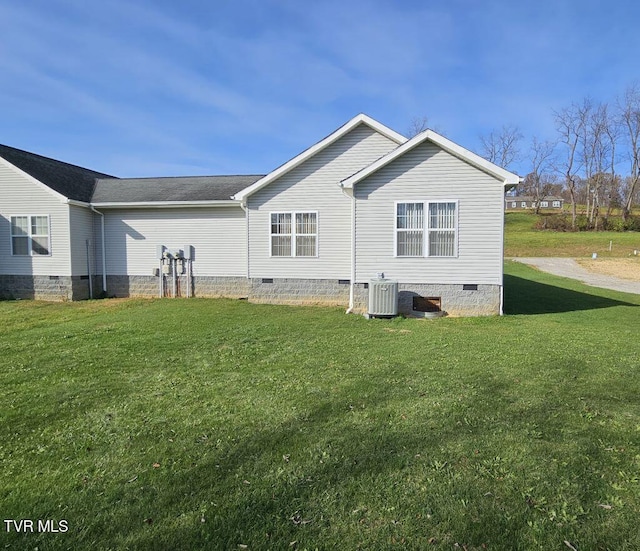 back of house featuring a yard and central AC