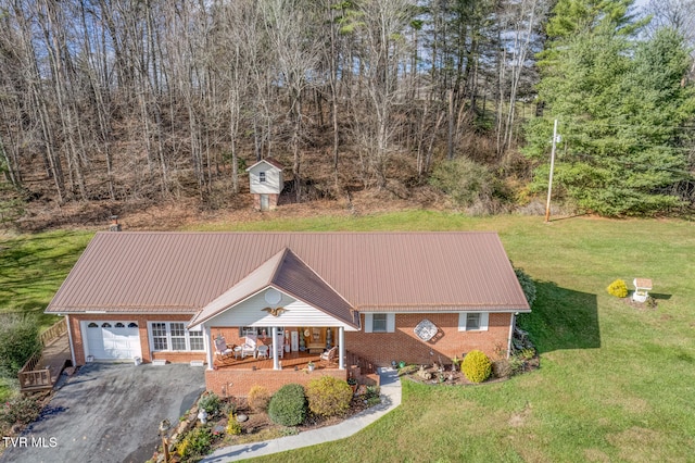 view of front of home with a storage shed, a front lawn, covered porch, and a garage