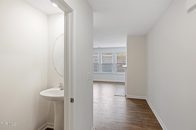 hall with a wall unit AC and dark hardwood / wood-style flooring