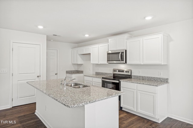 kitchen featuring appliances with stainless steel finishes, an island with sink, white cabinets, and sink