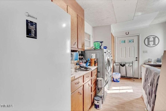 kitchen with light wood-type flooring, a textured ceiling, and white refrigerator