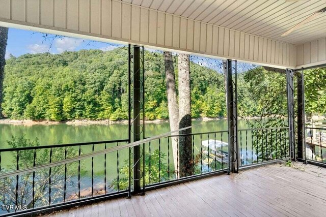 unfurnished sunroom featuring wooden ceiling, a water view, and a healthy amount of sunlight