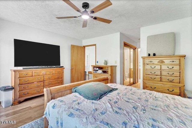 bedroom featuring ceiling fan, a textured ceiling, and light hardwood / wood-style flooring