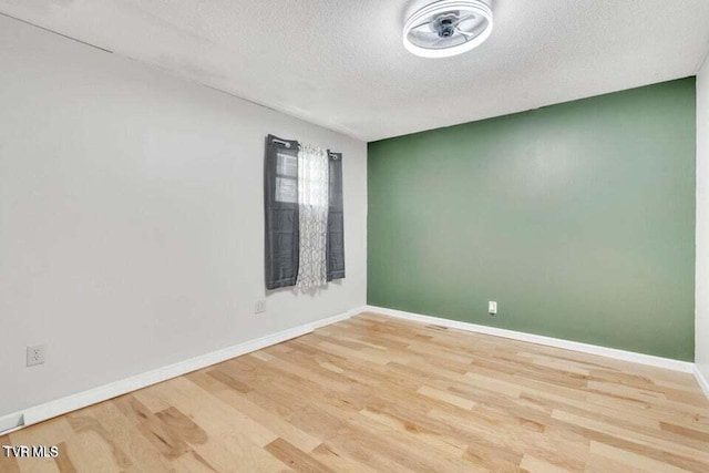 empty room featuring light hardwood / wood-style flooring and a textured ceiling