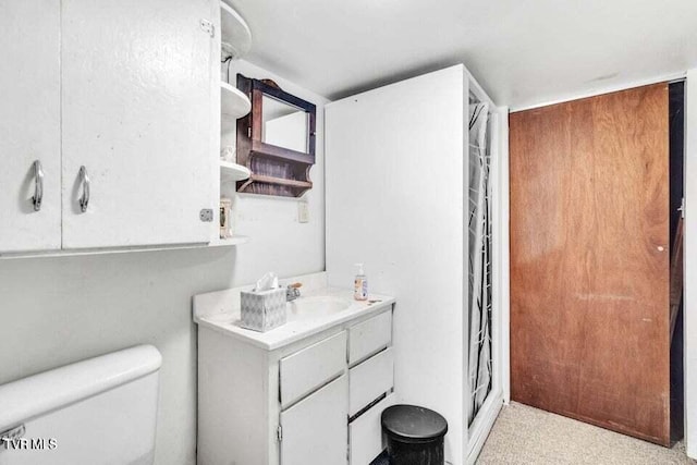 bathroom with a shower, vanity, and toilet