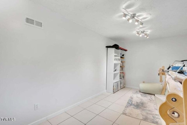 unfurnished room featuring light tile patterned flooring and a textured ceiling