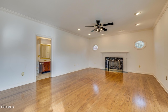 unfurnished living room with ceiling fan, ornamental molding, and light wood-type flooring