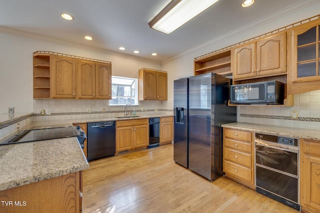 kitchen featuring sink, backsplash, crown molding, light hardwood / wood-style floors, and black appliances