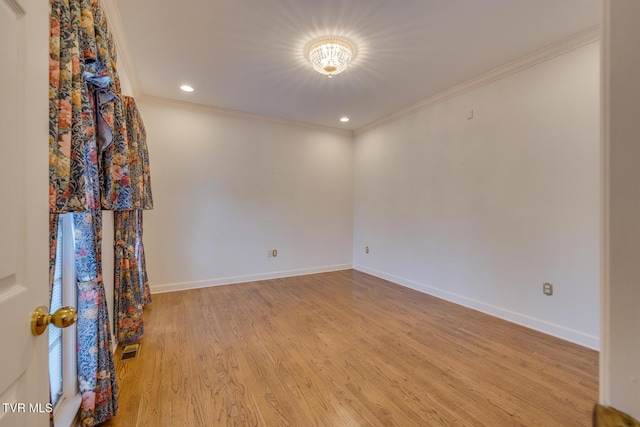 spare room featuring light hardwood / wood-style floors and crown molding