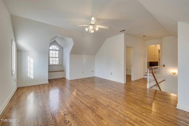 additional living space with ceiling fan, wood-type flooring, and vaulted ceiling