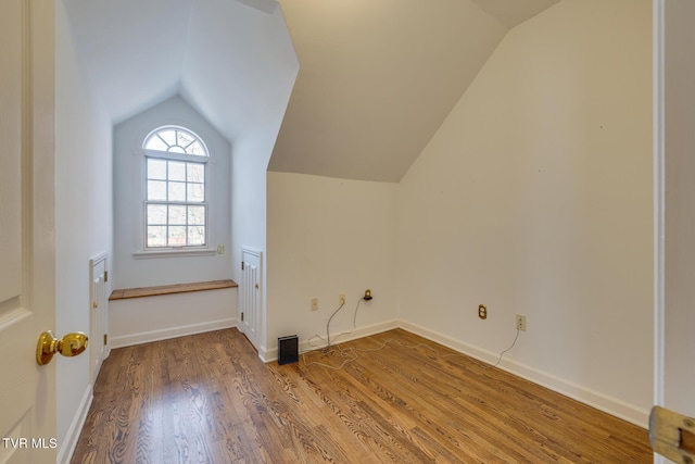 additional living space featuring hardwood / wood-style floors and vaulted ceiling