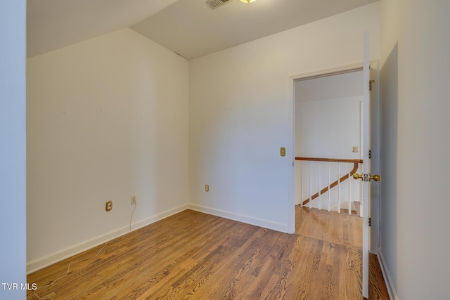 unfurnished room featuring hardwood / wood-style floors and vaulted ceiling