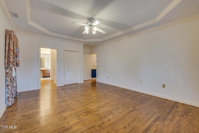 spare room featuring a tray ceiling, crown molding, ceiling fan, and hardwood / wood-style flooring