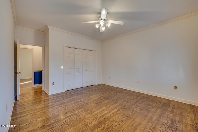 unfurnished bedroom with hardwood / wood-style floors, ceiling fan, ornamental molding, and a closet