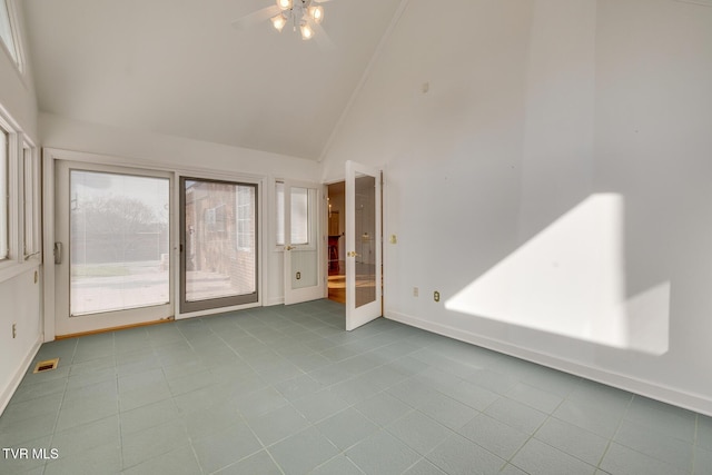 tiled empty room featuring high vaulted ceiling