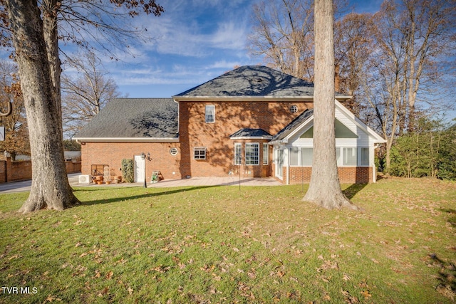 back of property with a yard and a patio area