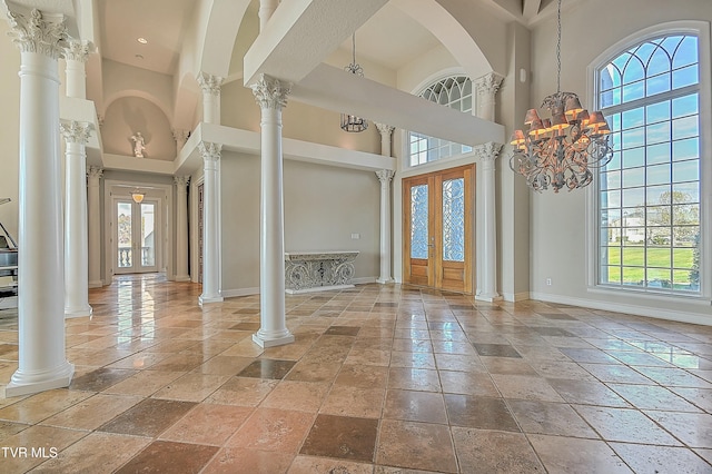 foyer entrance featuring french doors, a towering ceiling, and a chandelier